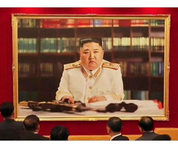 North Korea's Kim poses in military uniform with gun in new portrait